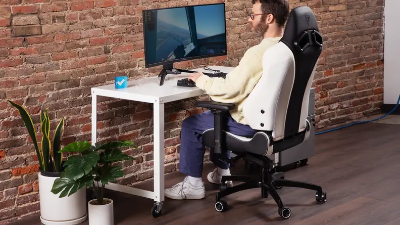 Person sitting in the black and white leather Vertagear SL5800 gaming chair