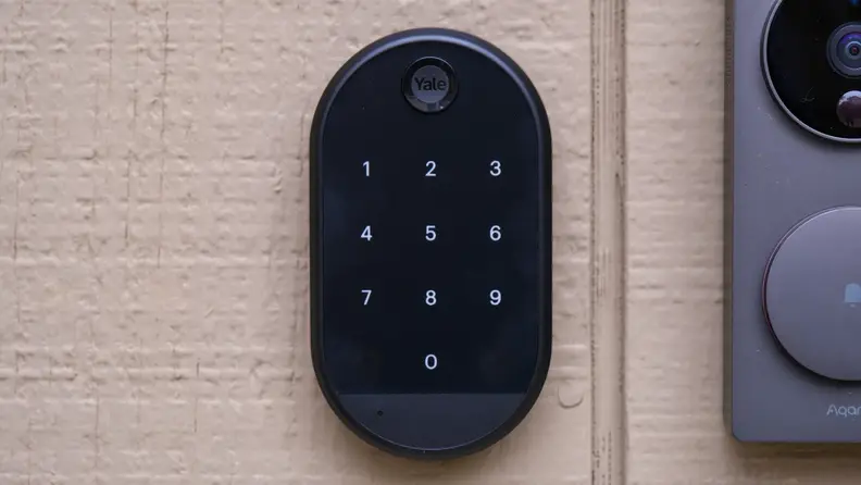 The advanced Yale Approach smart lock with the keypad shown in black, hanging on a door.