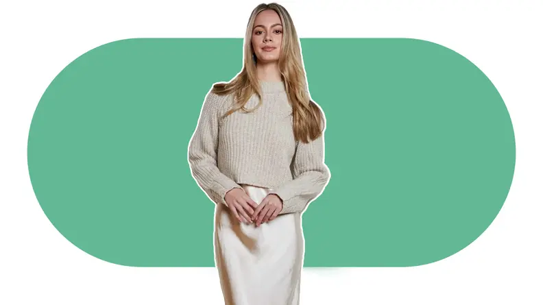 woman wearing cream sweater and slip on white and green background