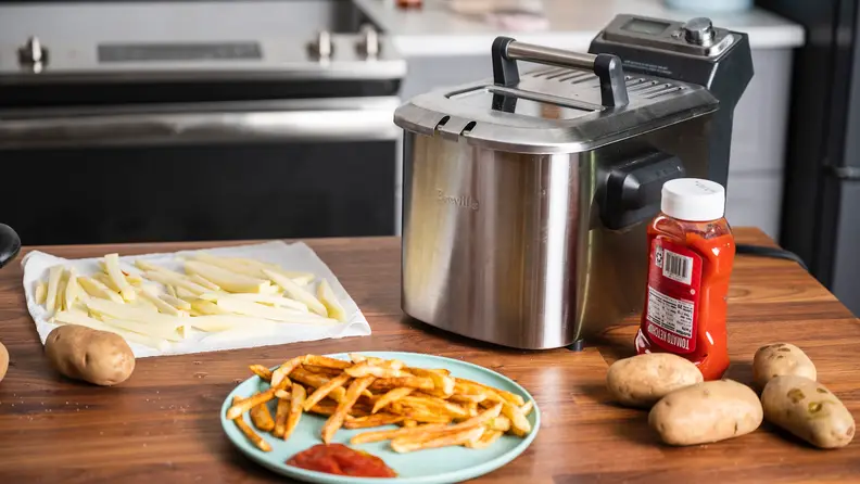 A Breville deep fryer sits on a kitchen counter.