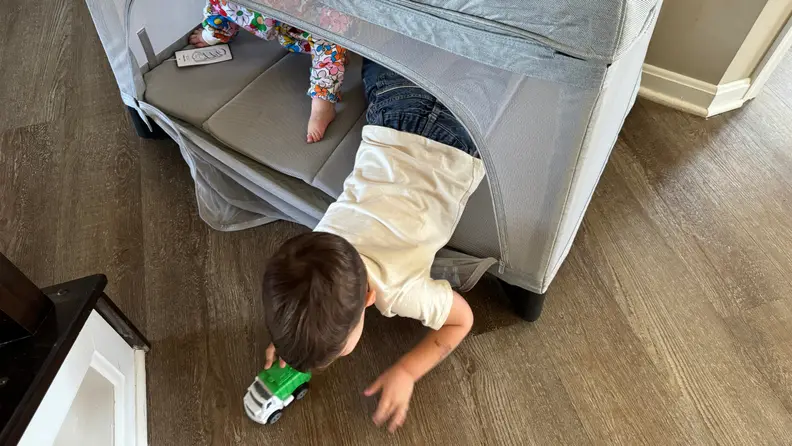 Two small toddlers playing inside of the Uppababy Remi playard.