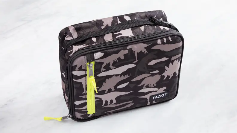 The PackIt Freezable Classic Lunch Box in dinosaur camo pattern on a marble counter.