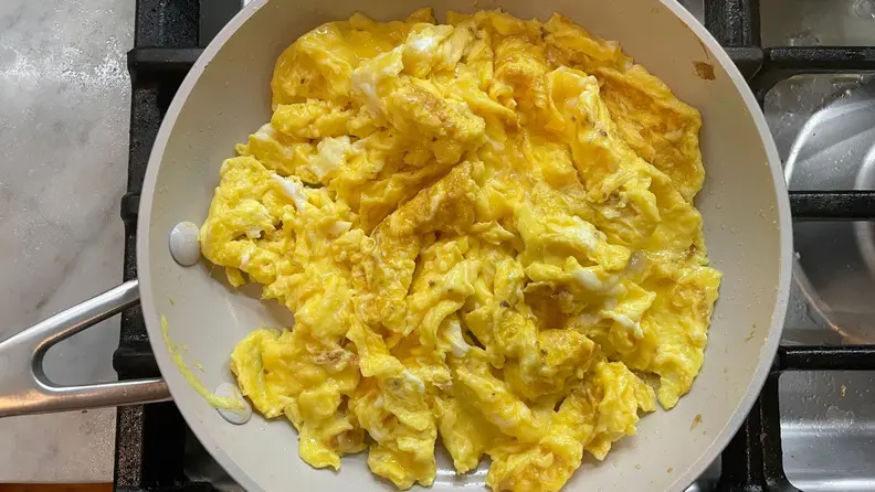 Prepared scrambled eggs on a pan.