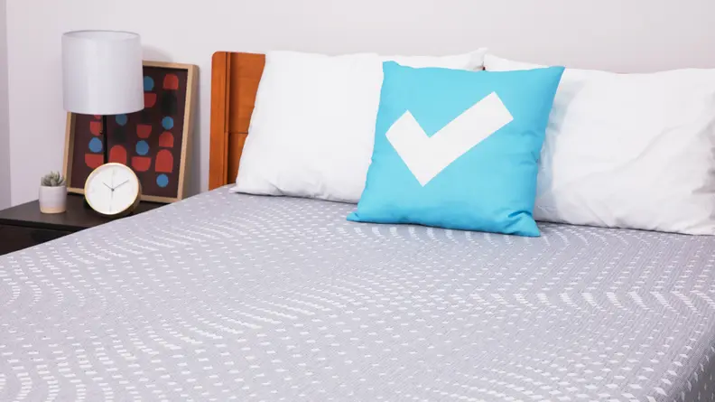 A closer view of the Sealy Posturepedic mattress with two pillows on top.