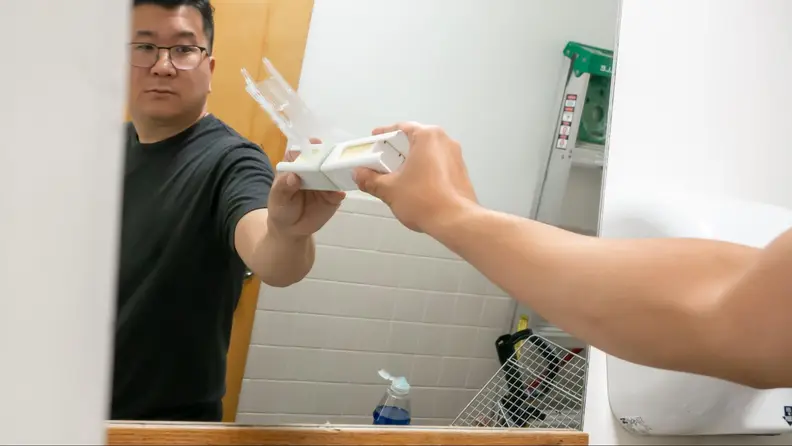 Mad man smearing butter on a mirror.