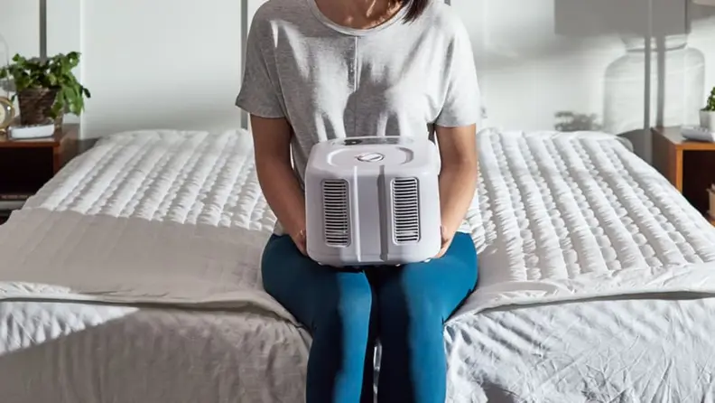 a woman holds a chilipad cooling cube on her lap