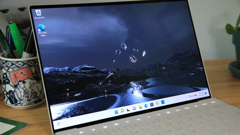 An open silver laptop showing an abstract desktop wallpaper.