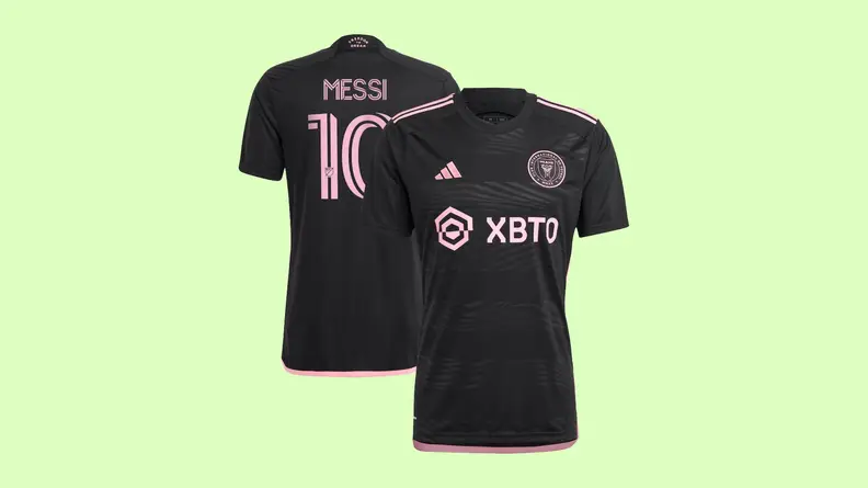 A black Inter Miami Lionel Messi jersey on a light green background.