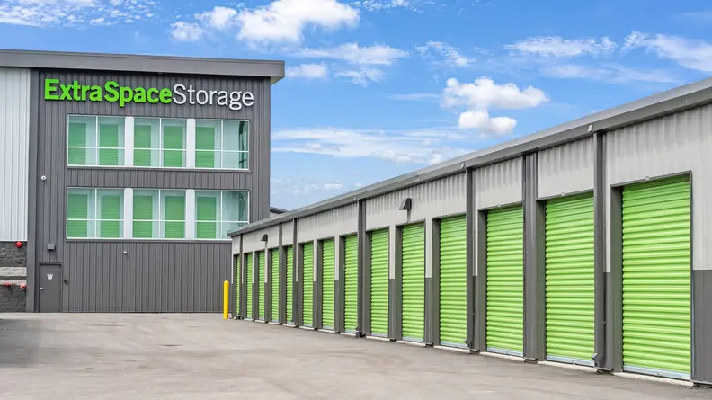 A parking lot with a large building and storage garages