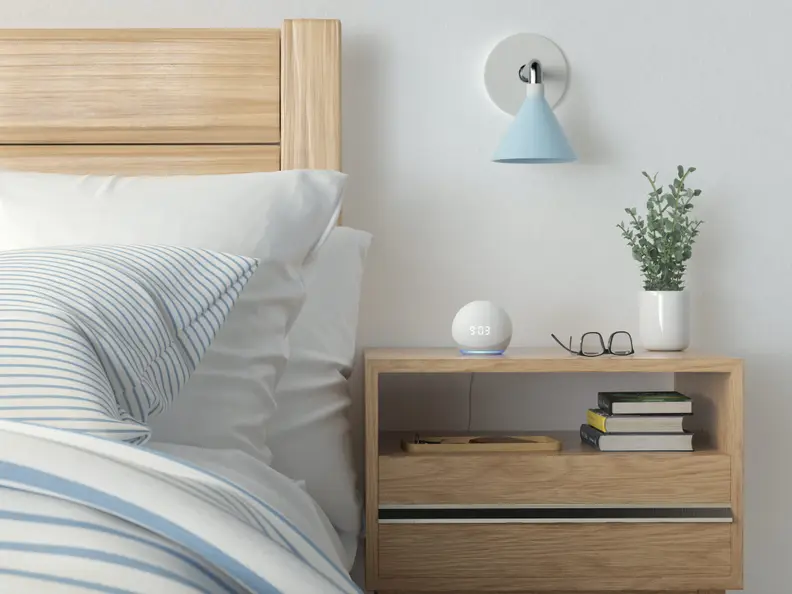 A smart alarm clock on a bedside table.