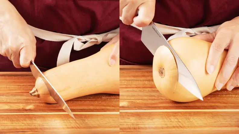 Person using sharp knife to remove top and bottom from butternut squash on top of wooden cutting board.