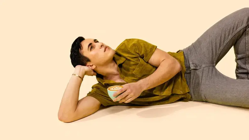 Chris Olsen laying on his side on a yellow background