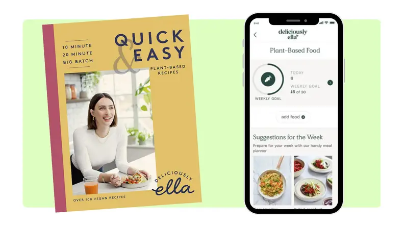 A plant-based cookbook next to a smart phone with a compatible phone app on screen.