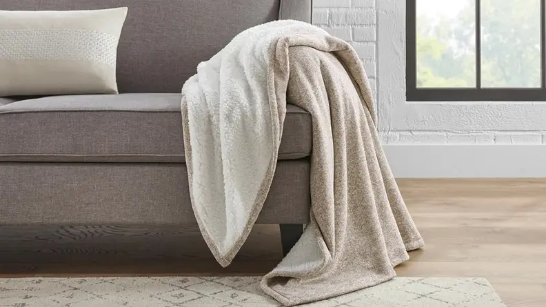 A fuzzy brown blanket thrown across a couch