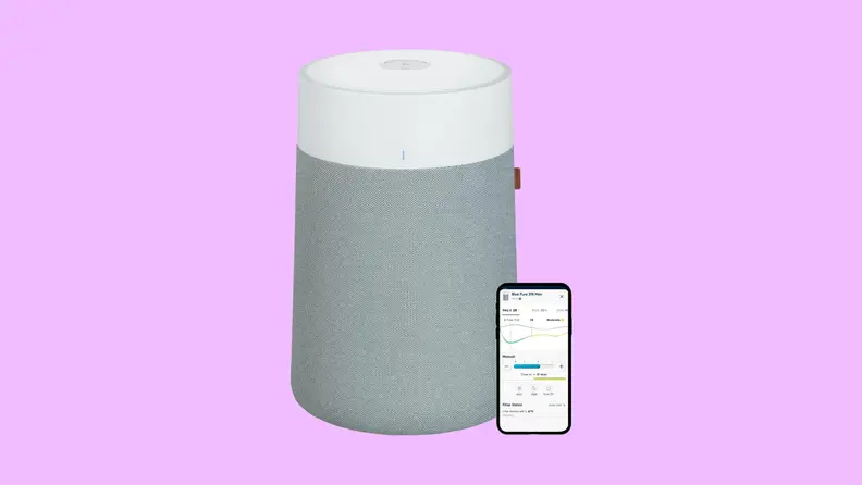 A gray, cylindrical Blueair Blue Pure 311i Max air purifier next to a cell phone that can control it with an app.