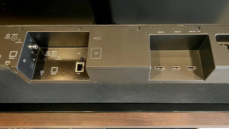 The black inputs section at the back of the bar shows multiple connections, including dual HDMI 2.1 and HDMI ARC