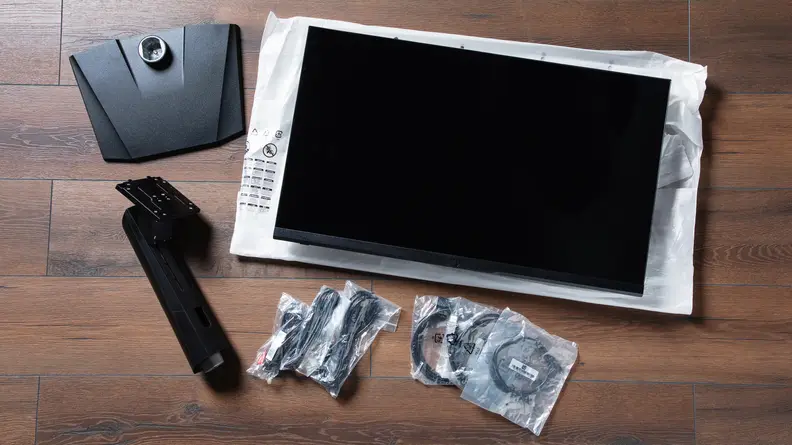 The contents of the MSI Optix MPG321QRF-QD, including the monitor stand and a few cables.