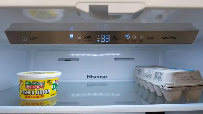 The control panel for the entire fridge right above a box of eggs and some butter.