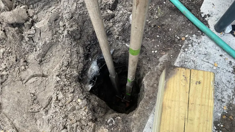 A hole on the ground being worked on to install posts.