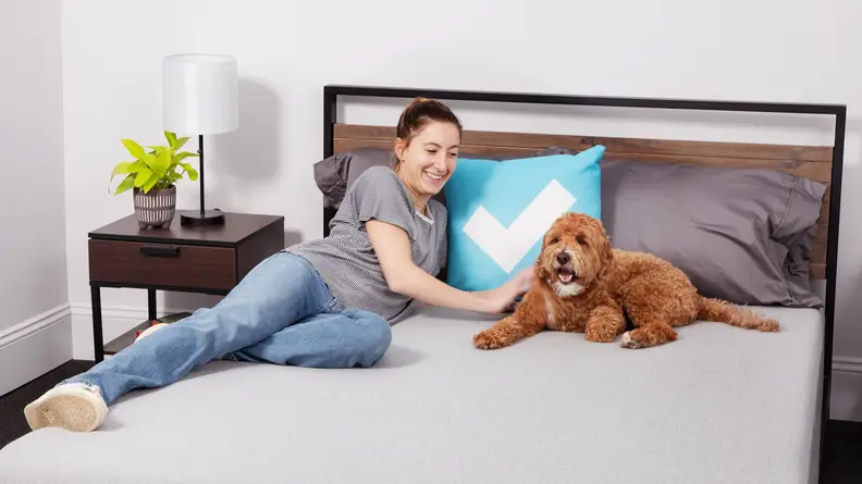 A person and a dog lying on The Casper foam mattress.