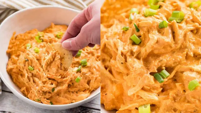 A hand digging into a bowl of buffalo chicken dip with a tortilla chip.