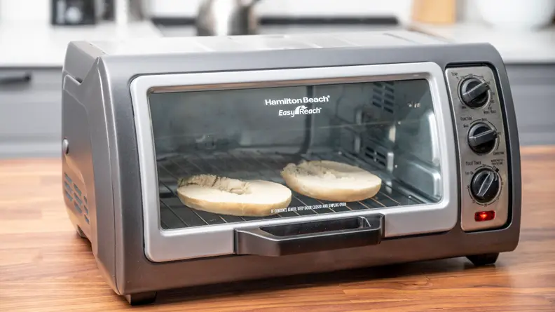 Bagel toasting in a Hamilton Beach toaster oven.