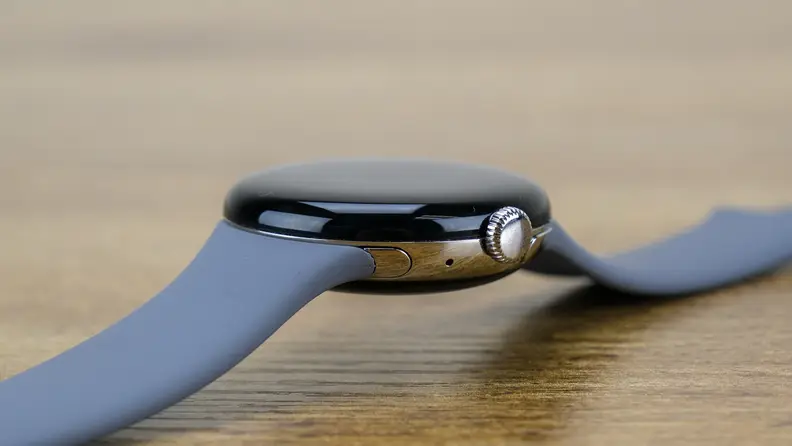 The Google Pixel watch is shown from the side with a black body and gray band.