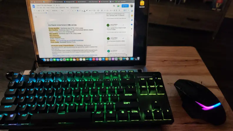 The SteelSeries Apex 9 on top of a laptop with a mouse next to it.