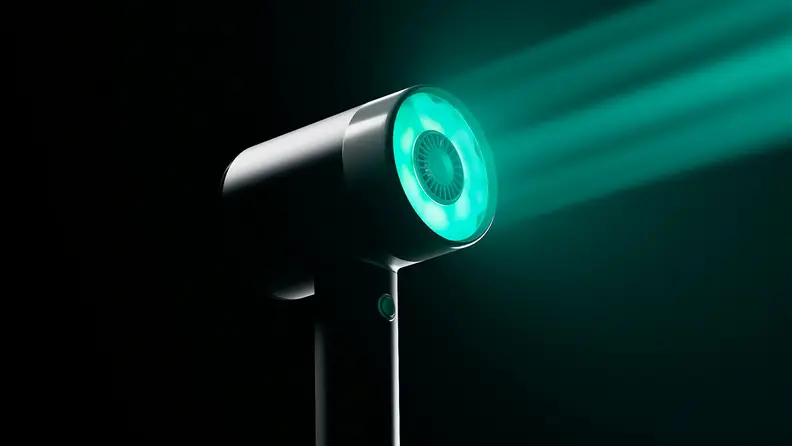 A L’Oreal Airlight Pro shining a teal-colored ray of light in the dark.