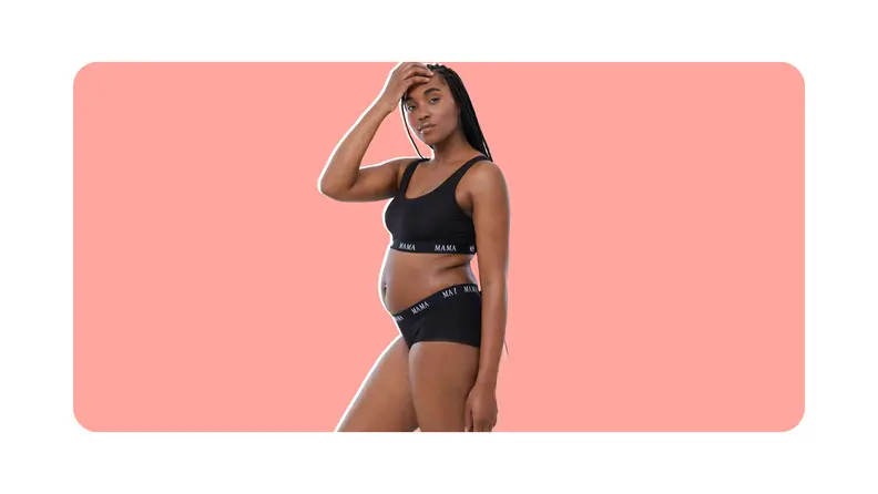 Pregnant person wearing two-piece black sports ra and underwear set from Ingrid+isabel with hand on forehead.