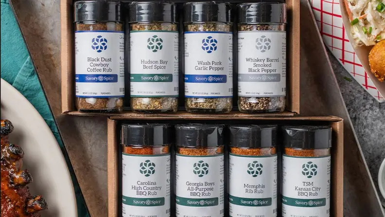 Two cases of Savory Spices next to cooked food.