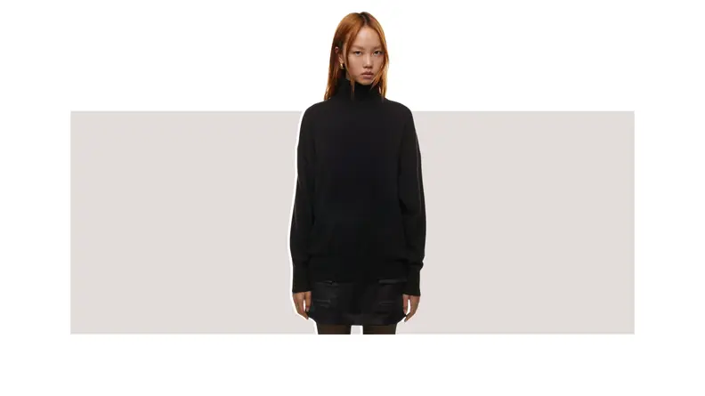 A model wearing a black turtleneck sweater.