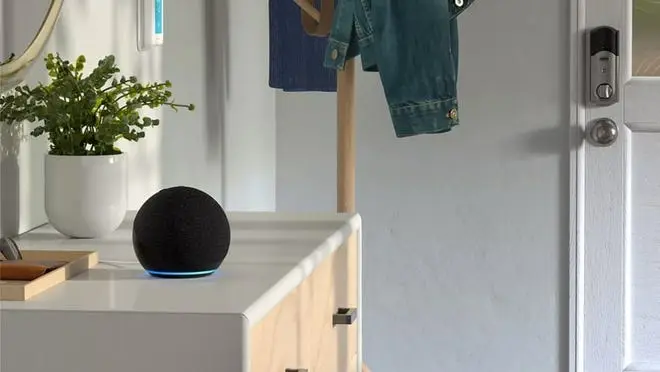 An Echo Dot sitting atop a dresser in a nicely furnished room.