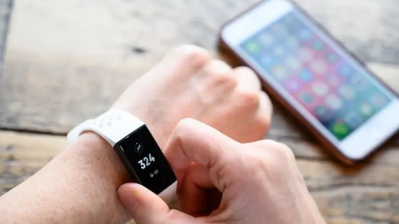 Close-up of a person wearing our pick for the best fitness tracker, the Fitbit Charge 4.