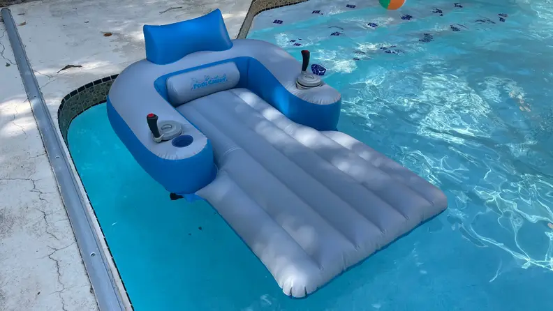 PoolCandy Splash Runner motorized pool float on top of pool water outdoors.