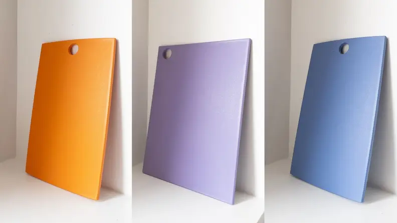 Three plastic cutting boards side by side.