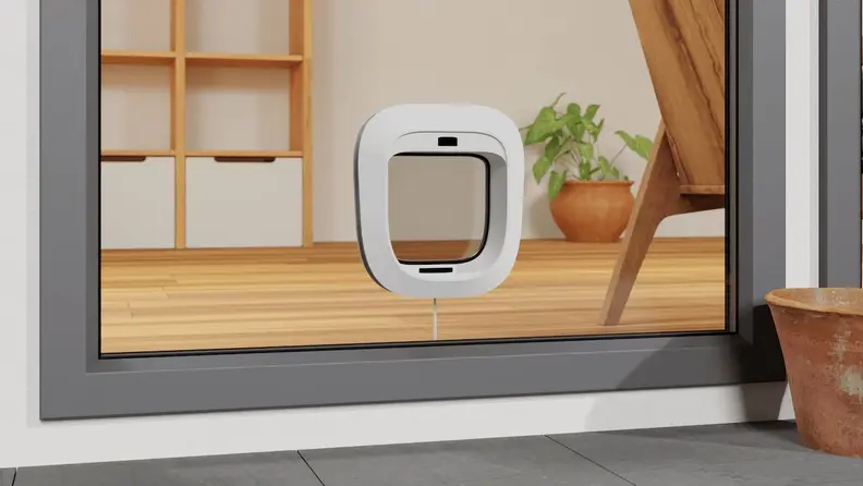 A Flappie AI enabled cat door that stops cats bringing mice into the house mounted in a glass window.