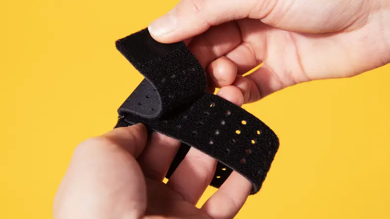Person using fingers to peel Velcro material on the black Liteboxer wrist straps.