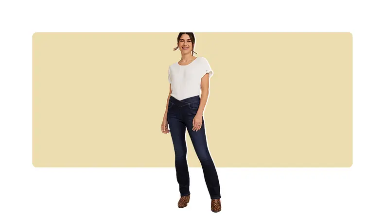 A model wearing dark bootcut jeans with a crisscrossed waistband and a white T-shirt.