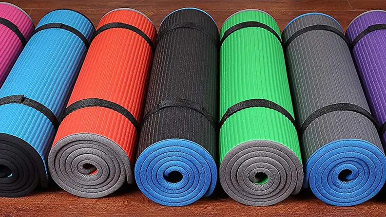 An image of pilates mats rolled up on the floor.