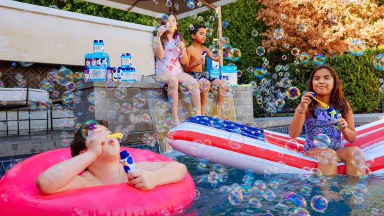 Kids in a pool blowing bubbles