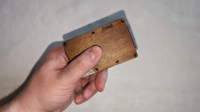 The Ridge Mopane Wood wallet being held in front of a white background.