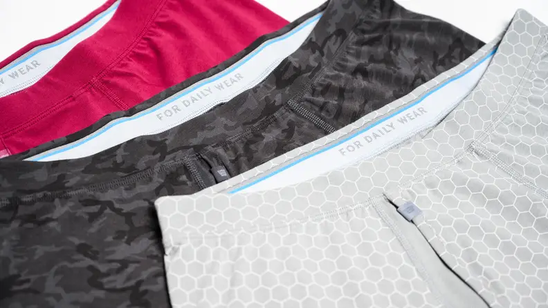 Three pairs of Mack Weldon boxer briefs cascading along a table.