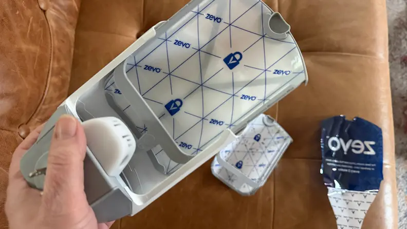 A hand changes the insert in one of the Zevo bug traps