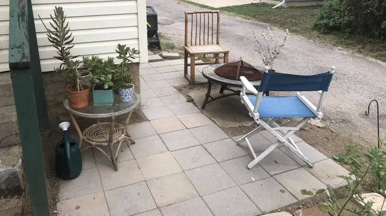 A small patio with folding chair and succulents.