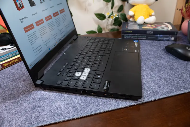 A side view of a black laptop, open and powered on