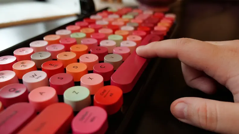 A finger pressing on the Ubotie Bluetooth Mechanical Keyboard spacebar.