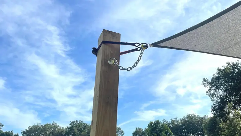 A pole with a corner of the shade sail attached to it.