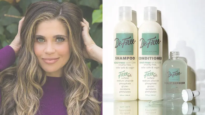 Danielle Fishel touches her hair and smiles.