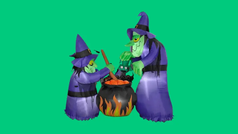 Two witches stir a cauldron in this Halloween decor.